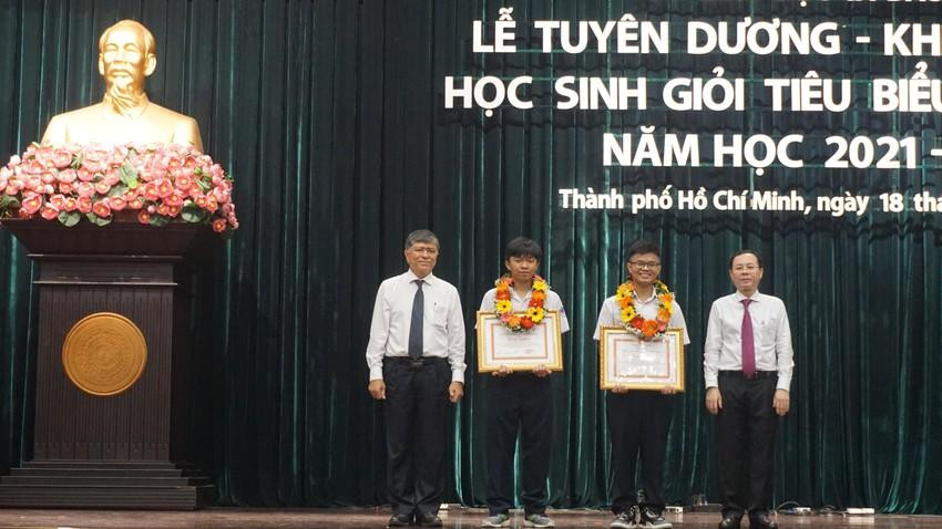Ông Nguyễn Văn Hiếu, Phó Bí thư Thành uỷ TPHCM (bìa phải) và ông Nguyễn Văn Hiếu, Giám đốc Sở GD&amp;ĐT TPHCM (bìa trái) trao tặng bằng khen cho hai học sinh đạt giải Olympic quốc tế. (Ảnh: NQ)