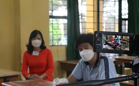 Thí sinh Thanh Bình ngồi trong phòng thi cùng cán bộ viết bài hộ trước máy ghi hình (ảnh: Én Bông) Thí sinh Thanh Bình ngồi trong phòng thi cùng cán bộ viết bài hộ trước máy ghi hình (ảnh: Én Bông)