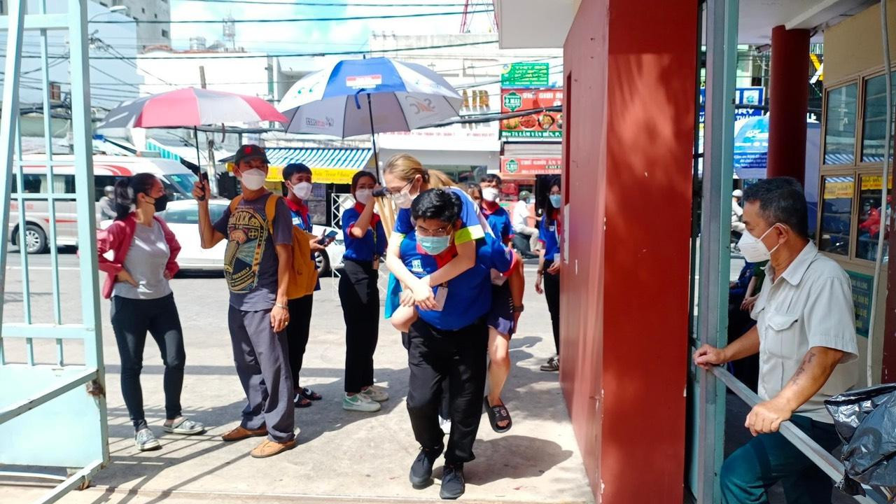 Tình nguyện viên cõng thí sinh vào phòng thi Tình nguyện viên cõng thí sinh vào phòng thi