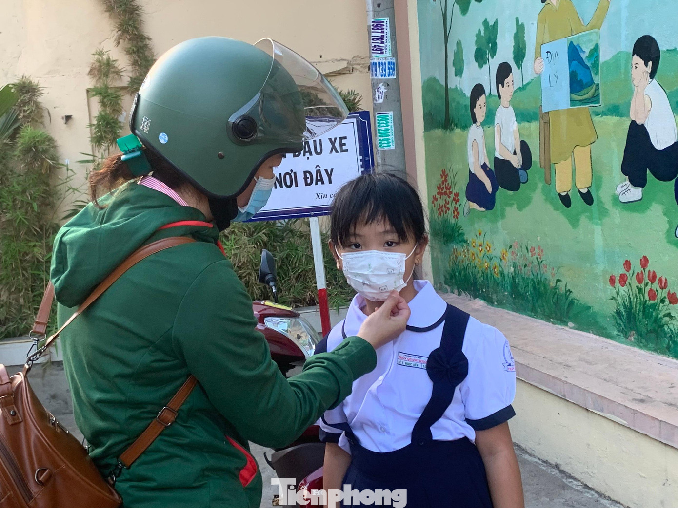 Một phụ huynh chỉnh lại khẩu trang, dặn dò con trước khi gửi cho cô giáo