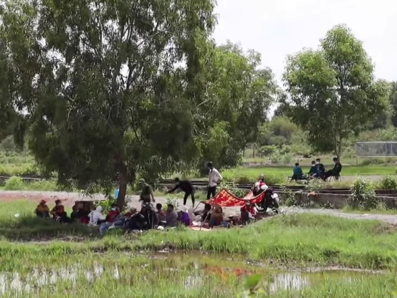 Người dân tá túc dưới tàng cây với hy vọng sẽ được thông chốt về quê.