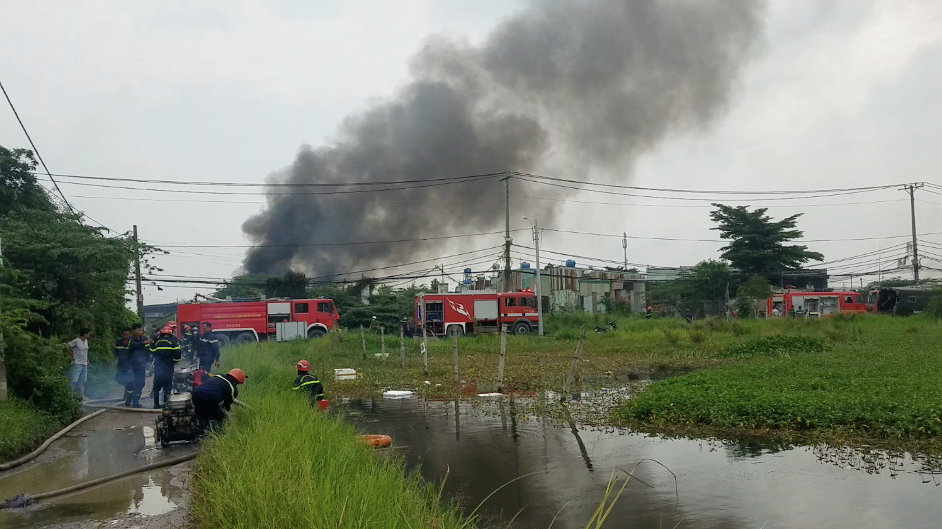 Lực lượng chức năng dùng máy bơm hút nước từ đầm ruộng, ao hồ gần hiện trường để dập tắt đám cháy.
