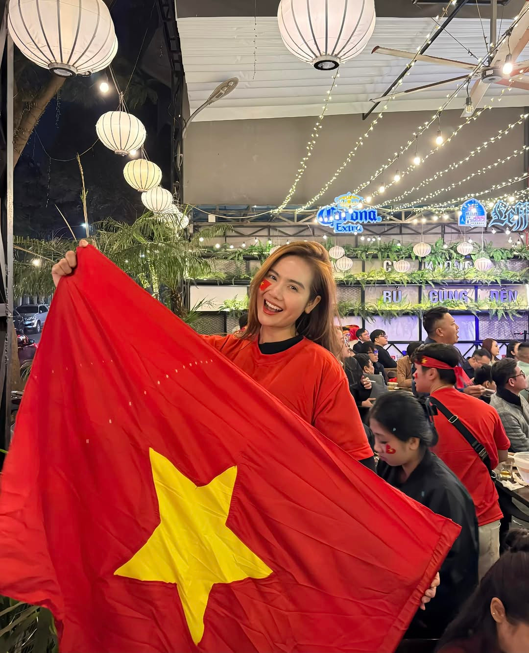 Huyền Lizzie trang bị đầy đủ áo và cờ đỏ sao vàng để đi "bão". Ảnh: IG.