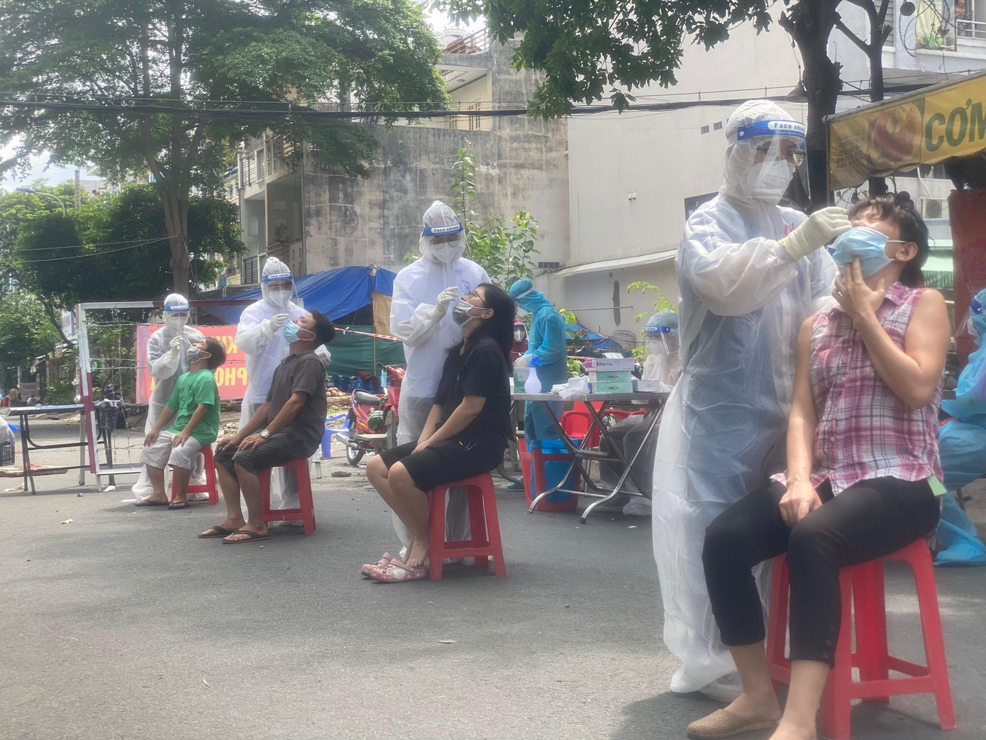 Bất kể thời tiết nắng mưa thất thường của Sài Gòn, mỗi ngày, một tình nguyện viên phải lấy mẫu xét nghiệm cho hơn 200 người dân