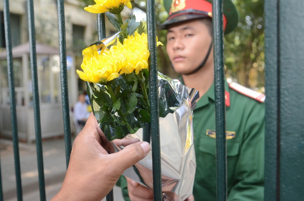 Các anh cảnh vệ liên tục nhận hoa từ người dân đến viếng
