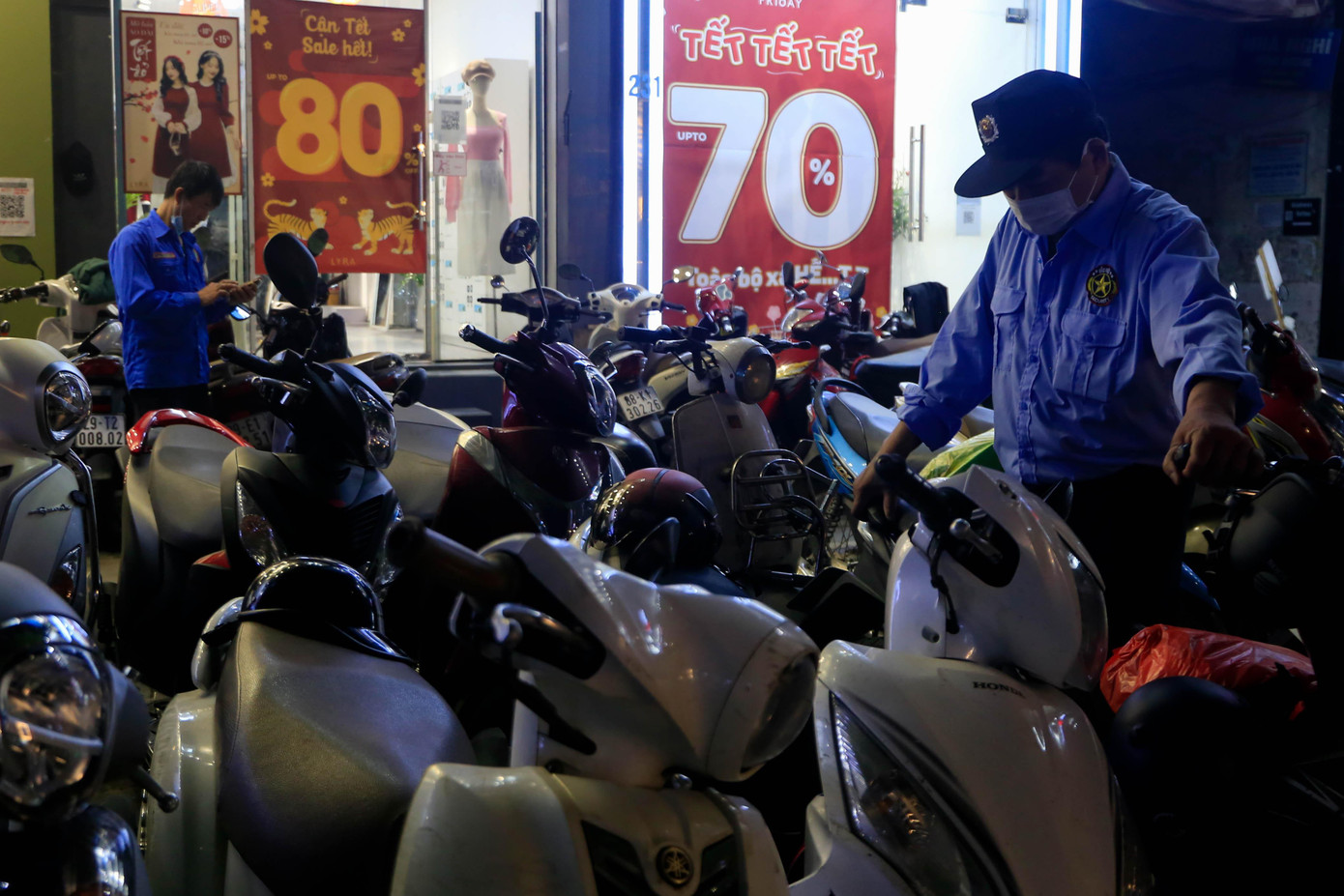 Vỉa hè trên các cửa hàng thời trang chật cứng xe máy của khách, bảo vệ tất bật xếp và phân luồng xe.