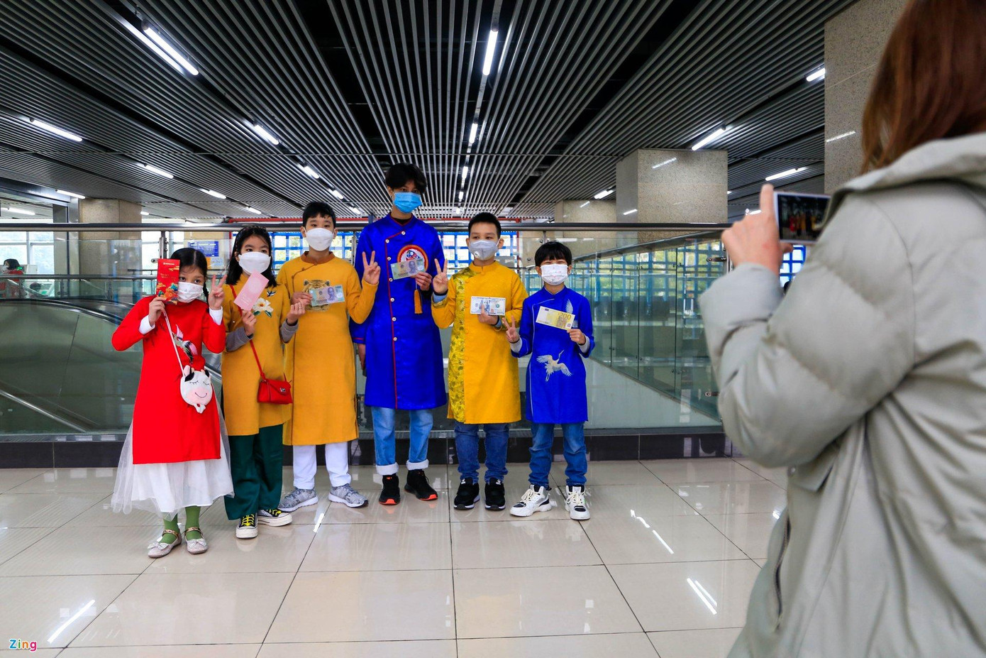 Chị Quỳnh và các con, cháu cũng đi du xuân, chơi Tết bằng tàu điện. Các bé diện áo dài nên đi bằng tàu điện sẽ ấm cúng hơn.