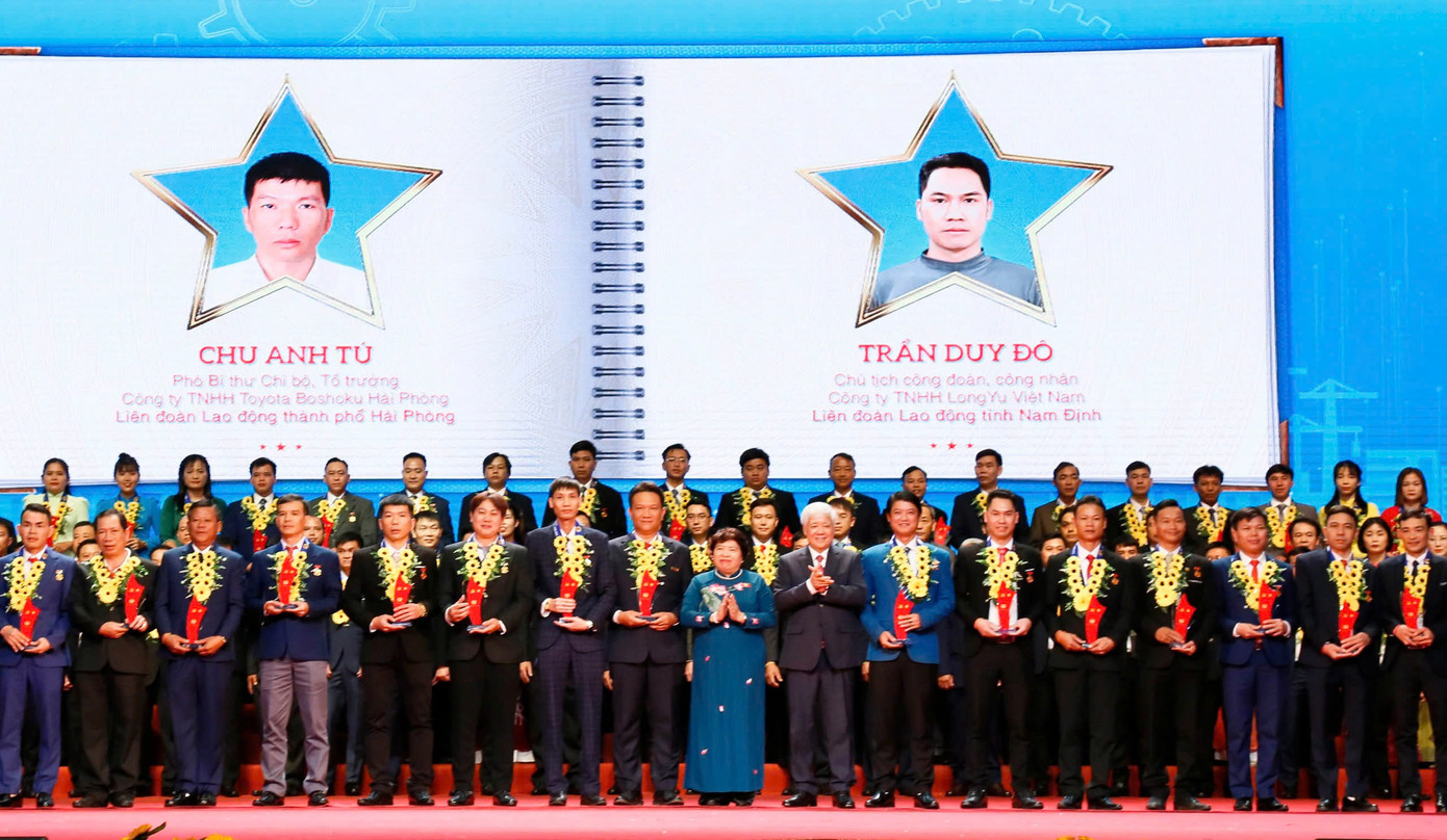 Anh Trần Quang Duy - EVNHCMC (cầm biểu trưng, đứng cạnh bà Nguyễn Thúy Anh (áo dài xanh) - Ủy viên Ủy ban Thường vụ Quốc hội, Chủ nhiệm Ủy ban Xã hội của Quốc hội) chụp ảnh lưu niệm cùng Lãnh đạo Đảng, Nhà nước, Tổng LĐLĐ Việt Nam