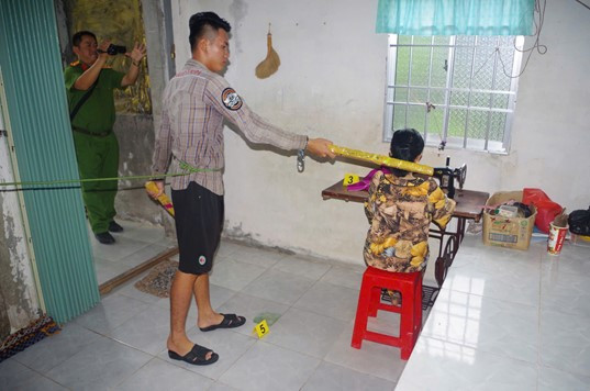 Phát mô phỏng lại hành vi dùng thanh gỗ đánh vào đầu bà Hiểu. Ảnh: Trọng Đạt.