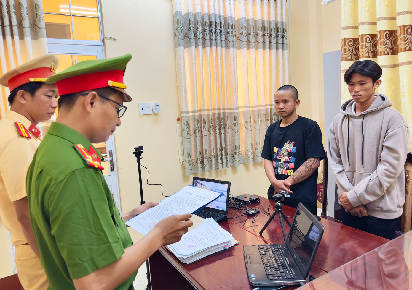 Công an tống đạt quyết định khởi tố bị can, lệnh cấm đi khỏi nơi cư trú đối với Võ Duy Khang (áo đen) và Phạm Văn Ý (áo xám). Ảnh: Trọng Nguyễn. Công an tống đạt quyết định khởi tố bị can, lệnh cấm đi khỏi nơi cư trú đối với Võ Duy Khang (áo đen) và Phạm Văn Ý (áo xám). Ảnh: Trọng Nguyễn.