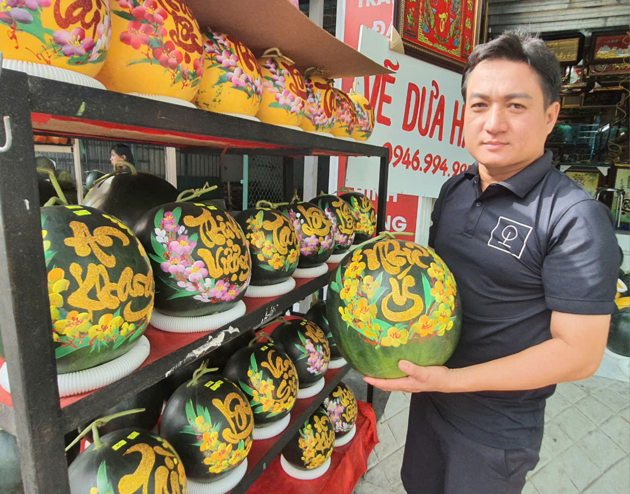 Gian hàng khắc chữ thư pháp trên dưa hấu của anh Trần Quốc Luẫn nằm ven đường Trần Huỳnh (TP. Bạc Liêu, tỉnh Bạc Liêu).