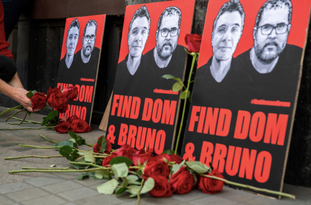 Đặt hoa tưởng niệm 2 nạn nhân trước cổng Đại sứ quán Brazil ở London. (Ảnh: Greenpeace)