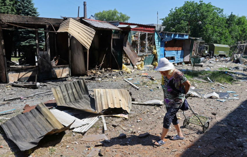Một cụ bà đi qua khu chợ đổ nát ở Donetsk ngày 19/6. (Ảnh: Reuters) Một cụ bà đi qua khu chợ đổ nát ở Donetsk ngày 19/6. (Ảnh: Reuters)