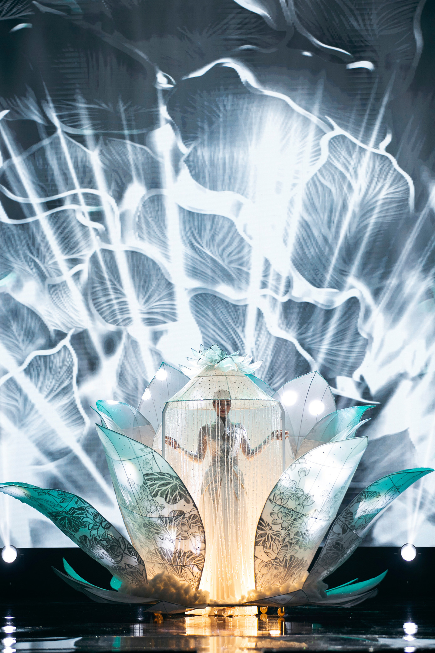 Hoa hậu Đoàn Thiên Ân kết show với tác phẩm Điệu Sen. Lấy cảm hứng từ hoa sen trắng, đại diện cho sự thanh khiết, trong sáng. Vẻ đẹp của đóa bạch liên cũng được ví như người phụ nữ với tâm hồn bao dung, ấm áp cùng nghị lực phi thường.