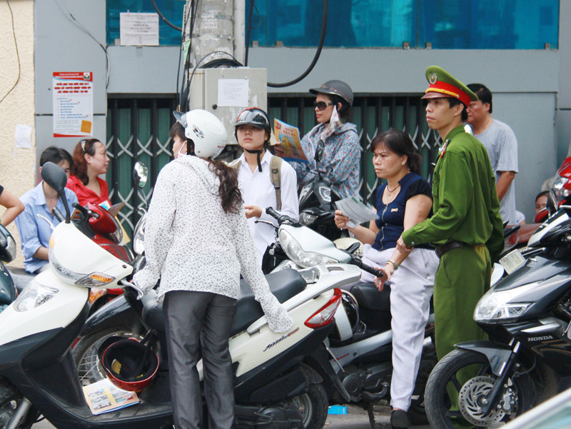 Gần đến giờ tan, lực lượng công an phải rất vất vả để điều khiển đám đông phụ huynh đứng chờ con dưới lòng đường