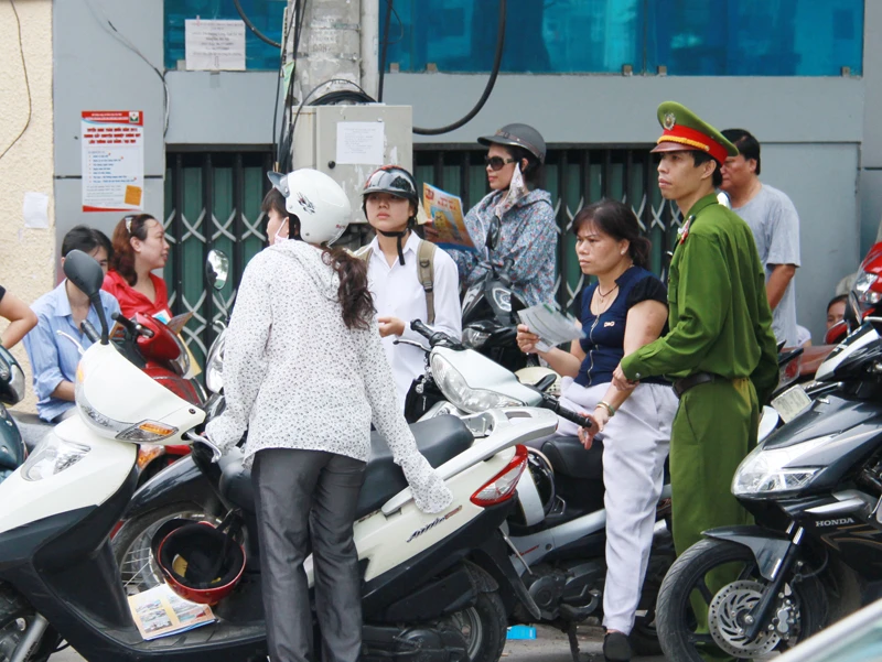 Gần đến giờ tan, lực lượng công an phải rất vất vả để điều khiển đám đông phụ huynh đứng chờ con dưới lòng đường