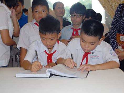 Học sinh tiểu học Trần Quốc Tuấn (TPHCM) ghi cảm xúc vào sổ tang ngày viếng Đại tướng. Học sinh tiểu học Trần Quốc Tuấn (TPHCM) ghi cảm xúc vào sổ tang ngày viếng Đại tướng