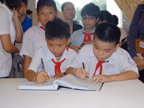 Học sinh tiểu học Trần Quốc Tuấn (TPHCM) ghi cảm xúc vào sổ tang ngày viếng Đại tướng