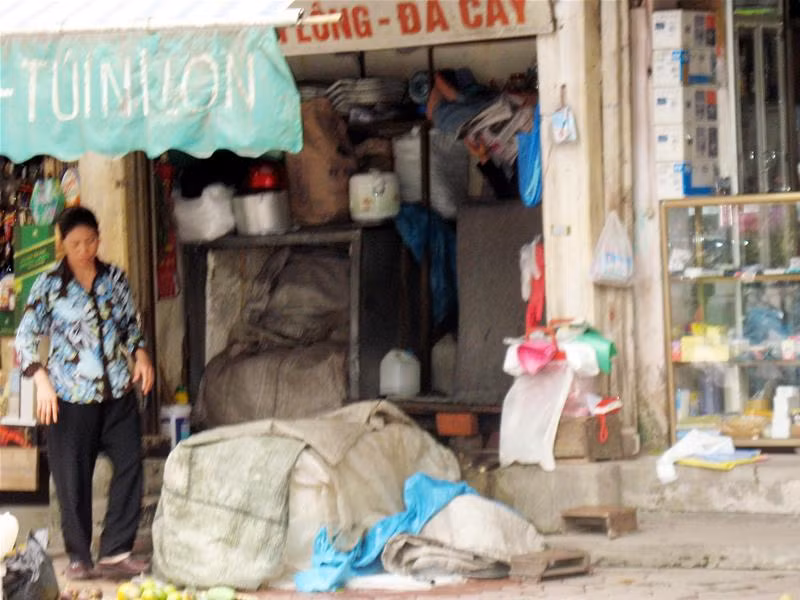 Chủ hàng đá cây trên đường Ngô Thì Nhậm (Hà Nội) với các bao tải để đựng đá cây trên vỉa hè. Đá cây trên phố Phùng Khắc Khoan, Hà Nội được trùm kín bằng bao tải.
