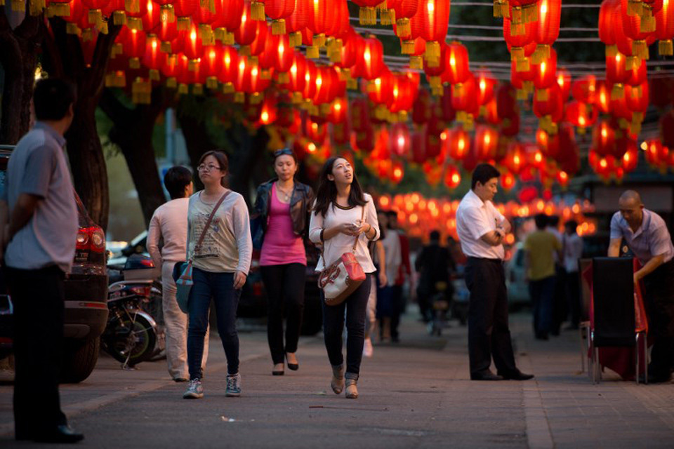 Du khách bước đi dưới một con phố treo đầy đèn lồng ở Trung Quốc