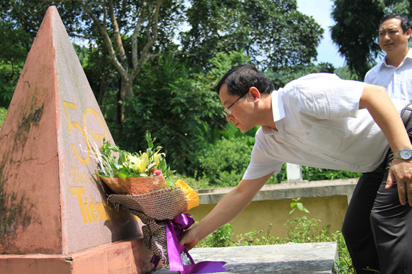 Ông Lê Xuân Sơn đặt hoa trước tấm bia kỷ niệm xây trên chính chiếc lán 60 năm trước từng là tòa soạn của báo Tiền Phong. Ảnh: Trường Phong