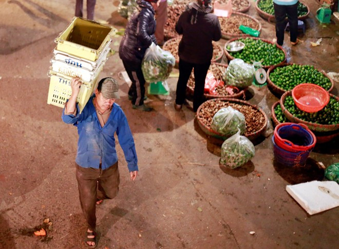 Một cửu vạn làm thời vụ tại chợ rau củ quả Đồng Xa (Cầu Giấy). Mỗi chuyến thồ và vác hàng họ kiếm được từ 20.000 - 30.000 đồng 