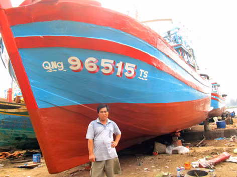 Tỷ phú Nguyễn Gia Viên bên con tàu đang sơn sửa để tiếp tục ra khơi. Ảnh: Nam Cường - Anh Thư