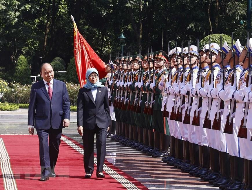 Chủ tịch nước Nguyễn Xuân Phúc và Tổng thống Cộng hòa Singapore Halimah Yacob duyệt Đội danh dự Quân đội Nhân dân Việt Nam. (Ảnh: Thống Nhất/TTXVN)