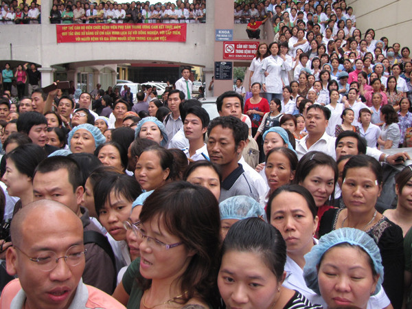 Đông đảo y bác sĩ , các sản phụ, người nhà đổ ra hành lang và sân bệnh viện chờ đón cháu bé trở về. Ảnh: Lãng Phong.