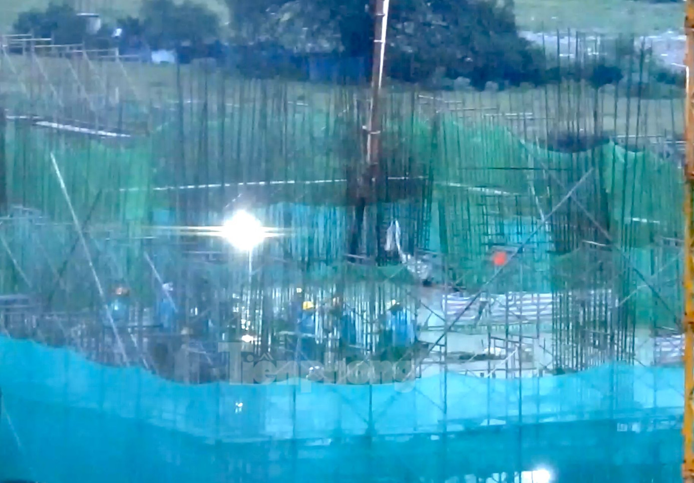 Hàng chục công nhân đội mưa trải bê tông. . Ảnh cắt từ clip.