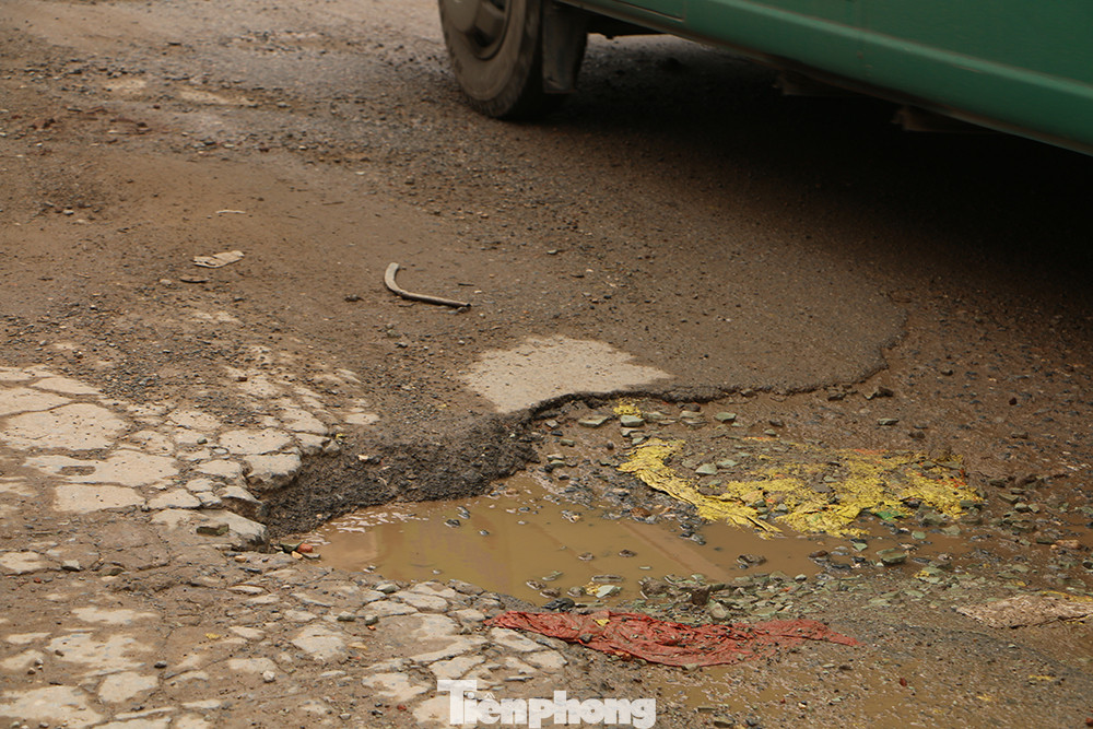 Mặt đường vỡ nát, bong tróc tạo thành hố.