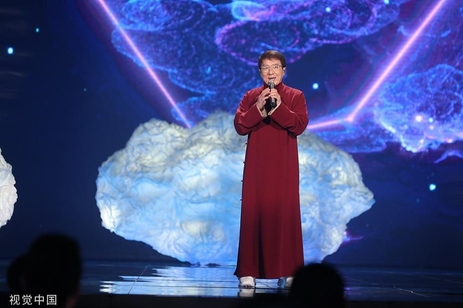 Thành Long biểu diễn trong bộ xường xám màu đỏ đô.