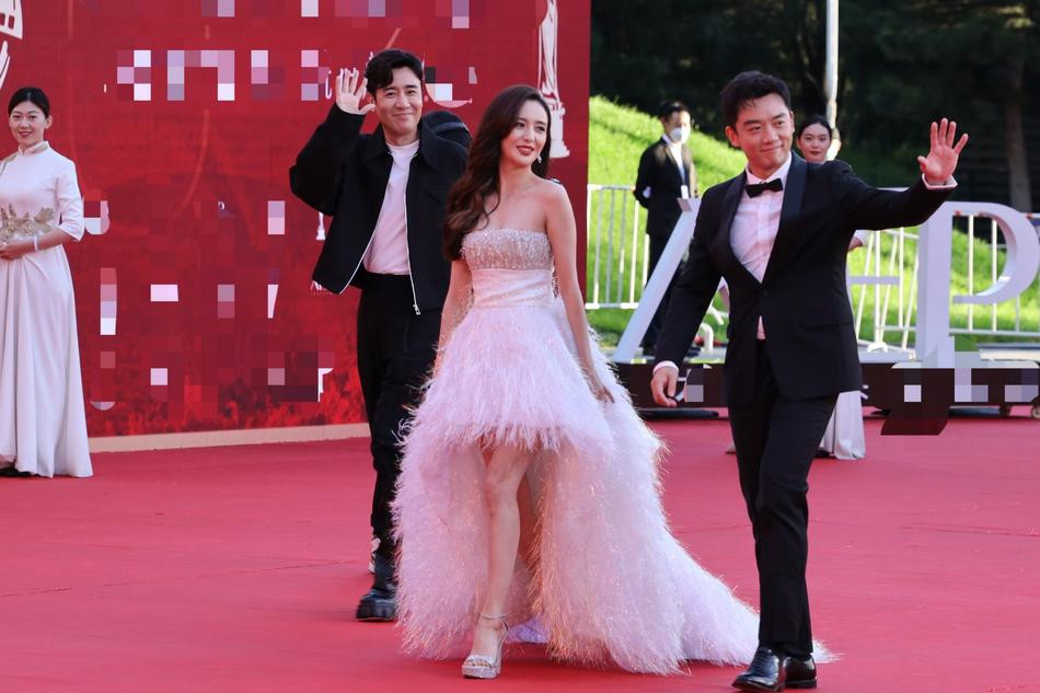 Mỹ nhân Tân Cương Đồng Lệ Á ngọt ngào với váy quây lông vũ. Cô được hai tài tử Vu Hòa Vỹ và Trịnh Khải (mặc vest) hộ tống lên thảm đỏ.
