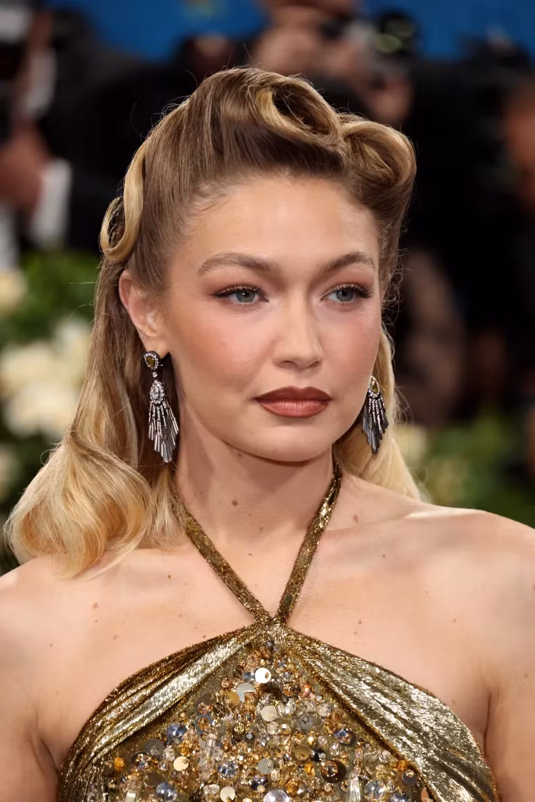 Gigi Hadid tạo kiểu tóc xoăn pin-up theo phong cách thập niên 40, kết hợp với trang điểm tông nâu trầm, tạo nên vẻ đẹp đầy nữ tính. Gigi Hadid tạo kiểu tóc xoăn pin-up theo phong cách thập niên 40, kết hợp với trang điểm tông nâu trầm, tạo nên vẻ đẹp đầy nữ tính.
