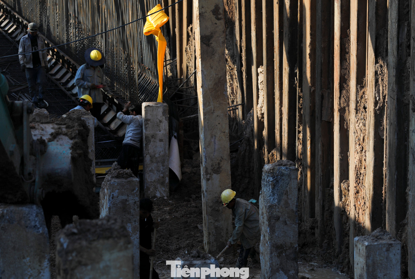 Bên trong công trường, nhiều công nhân, máy móc đang cấp tập thi công.