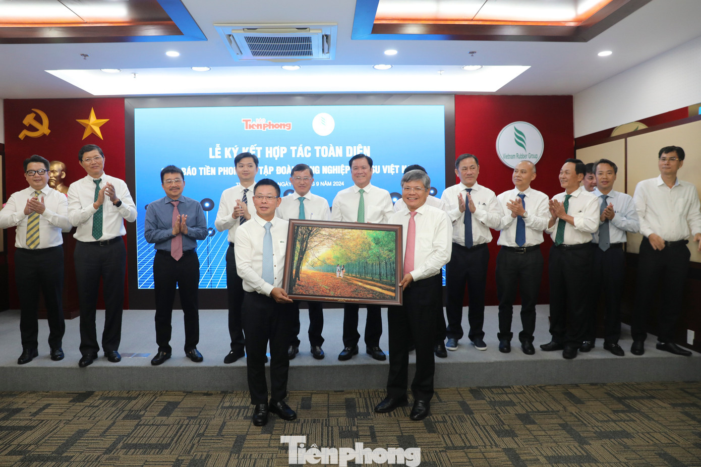 Đại diện Tập đoàn Công nghiệp Cao su Việt Nam (bên phải) tặng tranh lưu niệm cho Báo Tiền Phong.