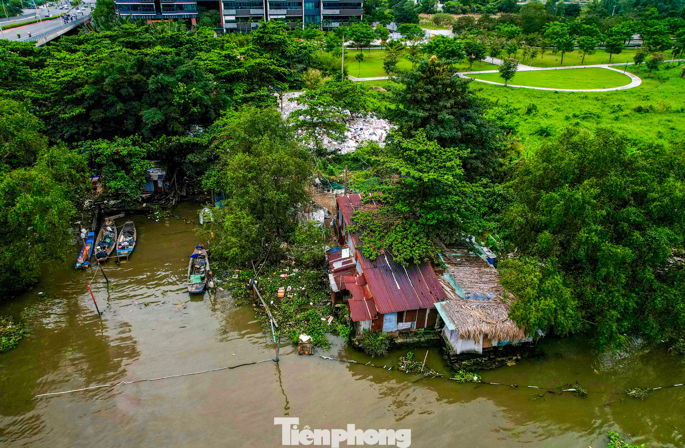 Dưới chân cầu Thủ Thiêm vẫn còn một số căn nhà lụp xụp ven sông cùng nhiều thuyền bè neo đậu.