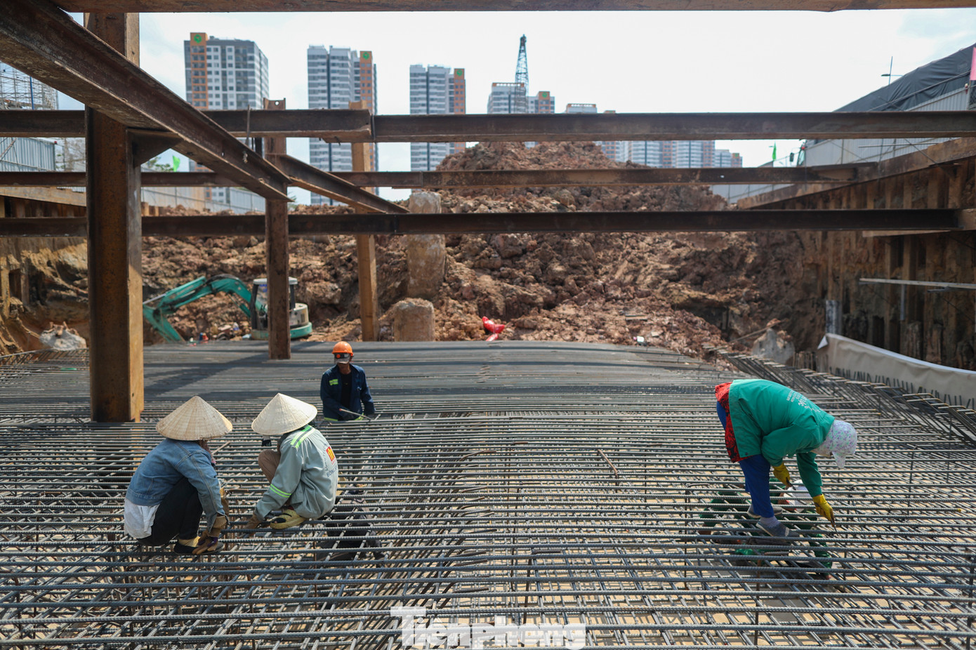 Tại công trường, nhiều công nhân vẫn phơi mình làm việc gấp rút để đảm bảo tiến độ dự án.