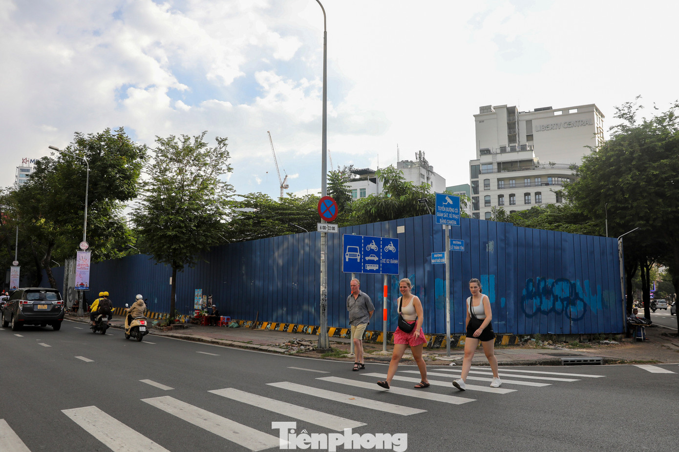 Xung quanh 4 mặt tiền quây kín tôn xanh, một bên mặt đường được tận dụng để xe rác.