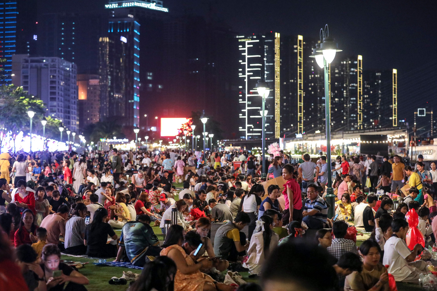 Tại công viên bến Bạch Đằng (quận 1, TPHCM) nhiều người đến sớm để "xí chỗ" đẹp, chờ xem pháo hoa đêm giao thừa. Thậm chí, có gia đình mang theo áo mưa, bạt trải, đồ ăn ngồi trên thảm cỏ. Ảnh: Duy Anh Tại công viên bến Bạch Đằng (quận 1, TPHCM) nhiều người đến sớm để "xí chỗ" đẹp, chờ xem pháo hoa đêm giao thừa. Thậm chí, có gia đình mang theo áo mưa, bạt trải, đồ ăn ngồi trên thảm cỏ. Ảnh: Duy Anh