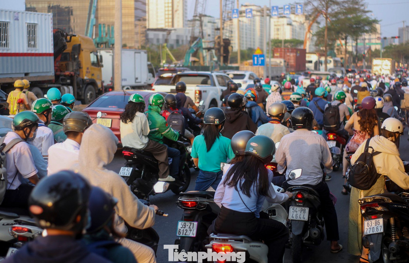 Người dân di chuyển bằng xe máy gặp nhiều khó khăn, làn xe container bị “chôn chân” trên đường 15-20 phút mới di chuyển được một đoạn ngắn.