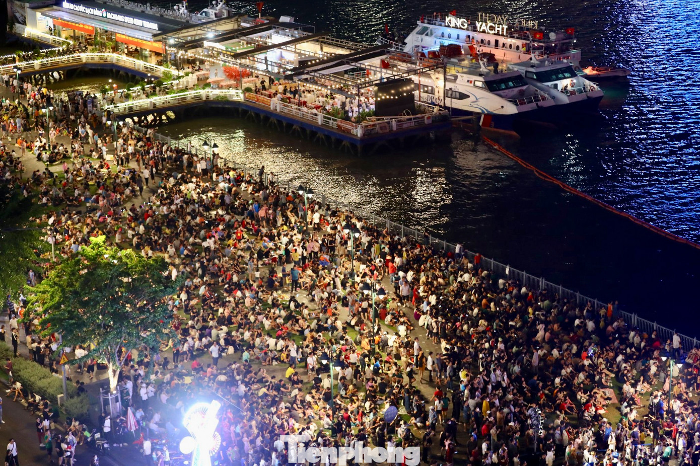 Tại công viên bến Bạch Đằng, nhiều gia đình mang theo bạt, áo mưa, đồ ăn trải ra thảm cỏ để chờ tới 21h.