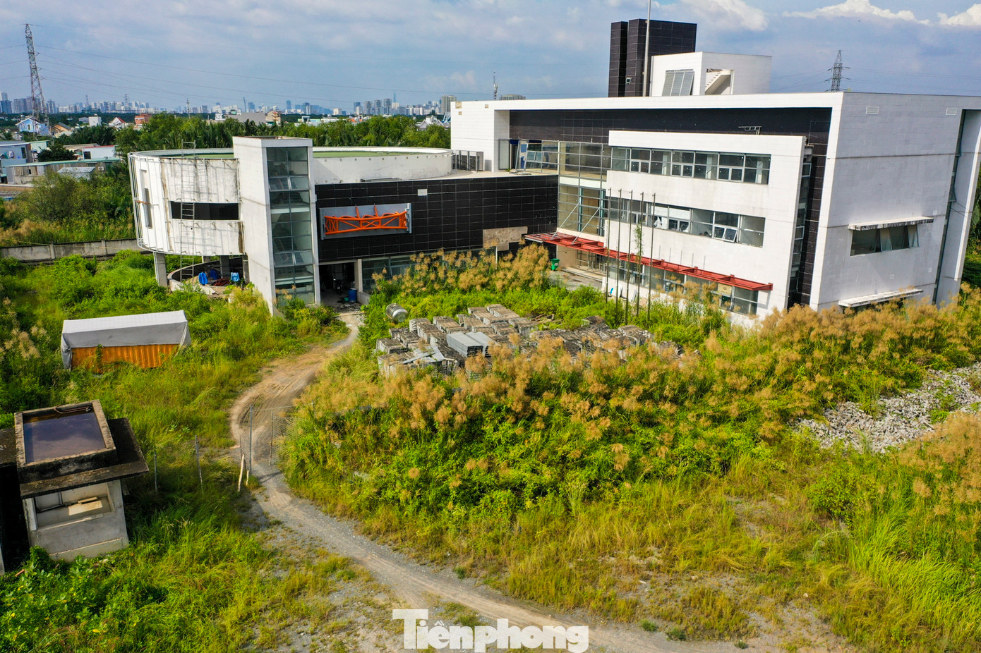 Hệ thống nhà điều hành bỏ hoang, cây cối phủ kín lối đi tạo nên một khung cảnh hoang tàn.