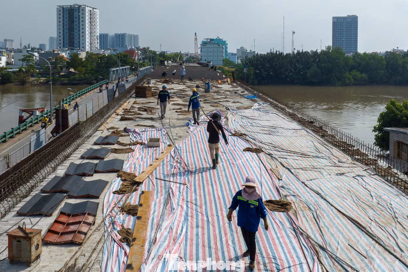 Ghi nhận vào đầu tháng 11, các công nhân đang khẩn trương thi công bản mặt cầu, lắp lan can và chuẩn bị thảm nhựa.