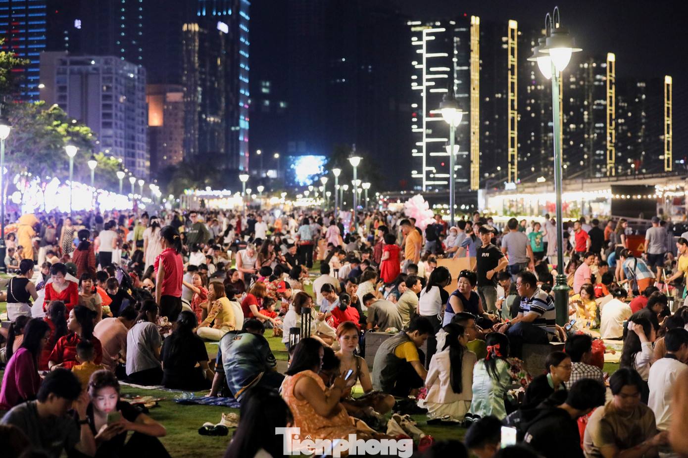 Tại công viên bến Bạch Đằng (quận 1, TPHCM) nhiều người đến sớm để "xí chỗ" đẹp, chờ xem pháo hoa đêm giao thừa. Tại đây có thêm dịch vụ cho thuê bạt tự phát với giá 20.000 đồng cho một tấm.