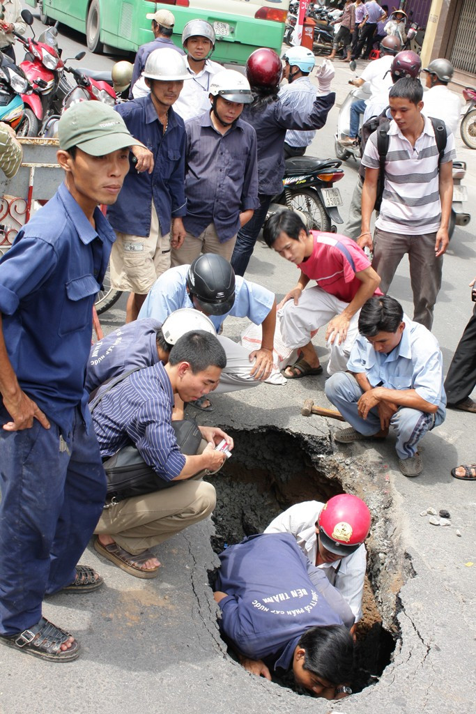 Người của Cty cấp thoát nước Bến Thành đang kiểm tra hiện trạng hố đen - ảnh T.H.V