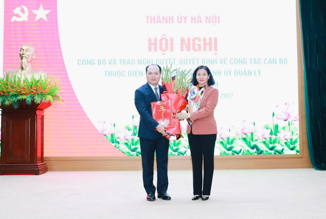 Phó Bí thư Thường trực Thành ủy Hà Nội Nguyễn Thị Tuyến trao Quyết định của Ban Thường vụ Thành ủy Hà Nội và tặng hoa chúc mừng ông Nguyễn Anh Dũng.