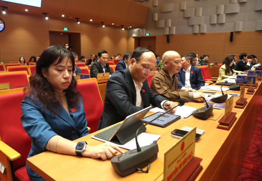 Các đại biểu bấm nút thông qua nghị quyết.