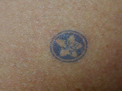 Giáo viên đóng dấu hoa đỏ lên mặt học sinh ngoan và hoa xanh lên mặt học sinh hư