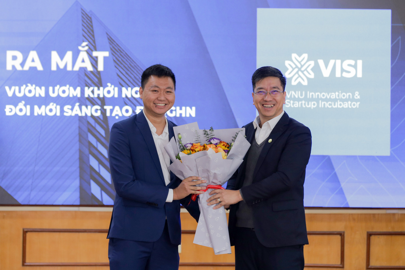 Giám đốc Trung tâm Chuyển giao Tri thức và Hỗ trợ Khởi nghiệp, ĐHQG HN Trương Ngọc Kiểm tặng hoa chúc mừng Giám đốc Vườn ươm Khởi nghiệp Đổi mới sáng tạo ĐHQG HN Trần Phi Long